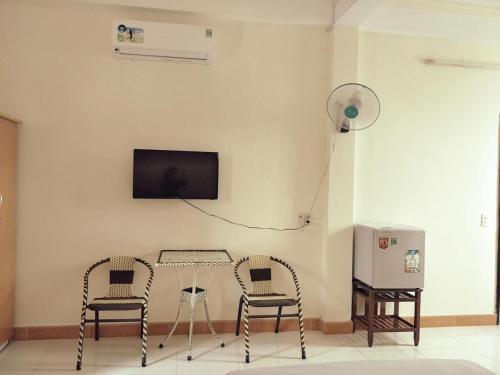 a room with two chairs and a table and a tv at Tuong Vy Hotel in Ho Chi Minh City