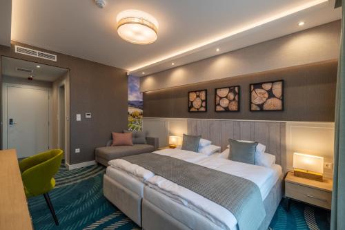 a hotel room with a large bed and a couch at Hotel Kőporos Hercegkút in Hercegkút