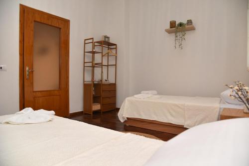 a room with two beds and a wooden door at Woodland in Berat
