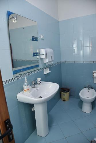 a blue bathroom with a sink and a toilet at Woodland in Berat