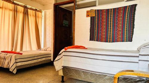 a bedroom with two beds and a window with curtains at Royal Palace Hostal in Panajachel