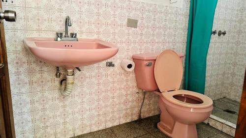 a bathroom with a pink toilet and a sink at Royal Palace Hostal in Panajachel