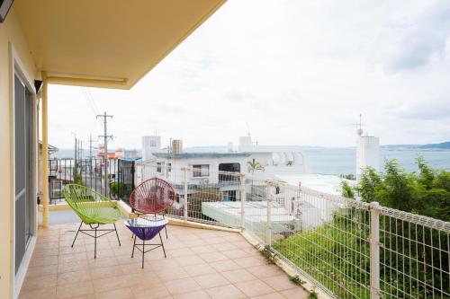 a balcony with chairs and a view of the ocean at  M’sOceanⅡ Uruma in Uruma