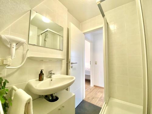 een witte badkamer met een wastafel en een douche bij Old Town Residence Schlossblick I Küche I Central in Füssen