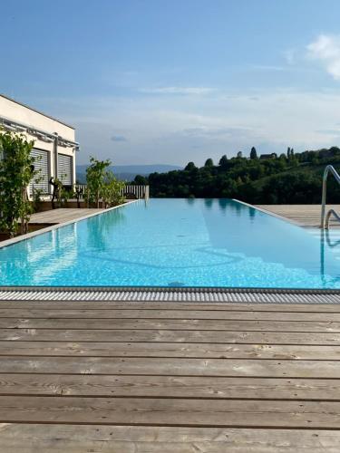 a large blue swimming pool with a wooden deck at Daheim an der Lage in Obegg