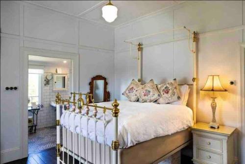 um quarto com uma cama, um candeeiro e um espelho em The White House - Spencer em Spencer
