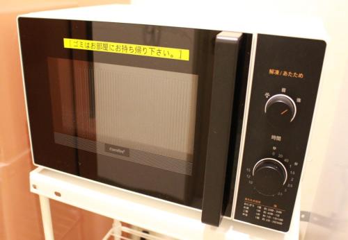 a microwave oven sitting on top of a shelf at HOTEL MYSTAYS Sapporo Aspen in Sapporo