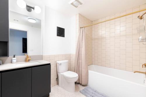uma casa de banho com uma banheira, um WC e um lavatório. em 2BR Hollywood Modern Luxury Condo em Los Angeles