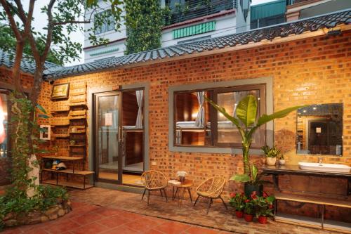 ニンビンにあるWafami Hostel Ninh Binhのレンガ造りの建物で、テーブル、椅子、シンクが備わります。