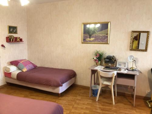 1 dormitorio con 1 cama y escritorio con ordenador en L'Eclipse, en Saint-Nicolas-des-Motets