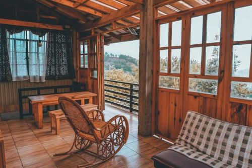 a living room with chairs and a table and windows at Mavy's Maligcong Homestay in Bontoc