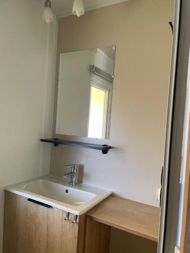 une salle de bain avec un lavabo et un miroir dans l'établissement Mobilhome Ck135 Siblu Les Charmettes, aux Mathes