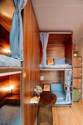 a room with two bunk beds and a table at Wafami Hostel Ninh Binh in Ninh Binh
