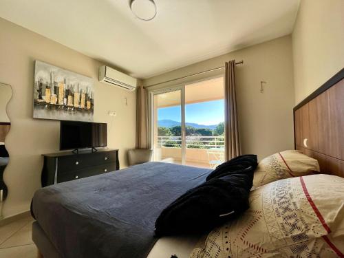 Un dormitorio con una cama grande y una ventana. en Appartement Résidence Salin Bay, en Porto Vecchio