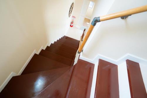 a staircase with brown wooden floors and a wooden rail at  M’sOceanⅡ Uruma in Uruma