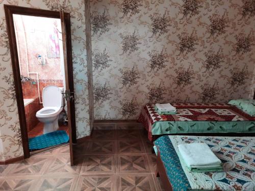 y baño con 2 camas y aseo. en Inn Sogdiana, en Panjakent