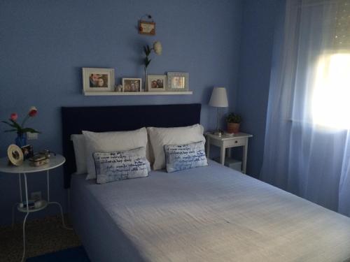 a blue bedroom with a bed with two pillows at URBION HOME in Seville