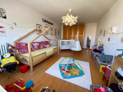 ein Kinderzimmer mit einem Kinderbett und einem Bett darin in der Unterkunft JO maison spacieuse 10 mn Paris in Villejuif