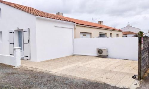 a white house with a white fence and a driveway at Maison proche centre, gare, aux Sables d'olonne in Les Sables-dʼOlonne