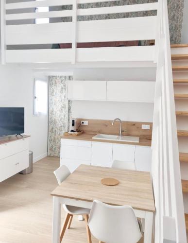a kitchen and dining room with a table and chairs at Maison proche centre, gare, aux Sables d'olonne in Les Sables-dʼOlonne