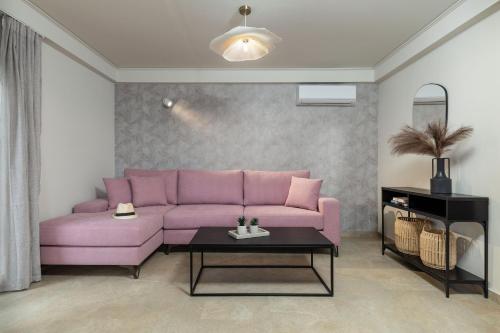 アテネにあるVouliagmeni Stylish Homes by BluPineのリビングルーム(ピンクのソファ、テーブル付)