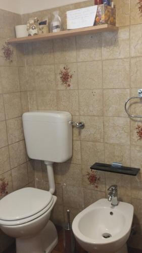 La salle de bains est pourvue de toilettes et d'un lavabo. dans l'établissement B&B SòT AL PIZ, à Sagron Mis