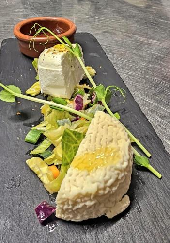 a plate with cheese and salad on a table at Vilajoun in Joucas