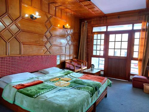 - une chambre avec un grand lit dans une pièce dotée de murs en bois dans l'établissement Hotel Radha Continental Nainital Near Mall Road - Hygiene & Spacious Room - Prime Location - Best Selling, à Nainital