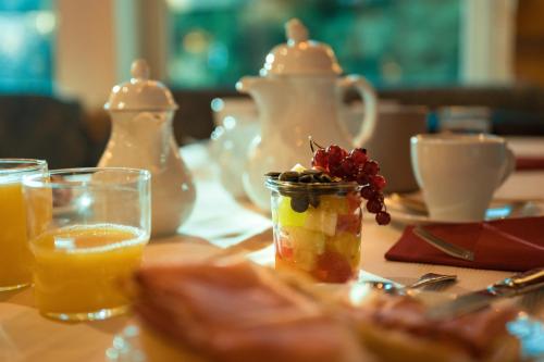 拜爾斯布龍的住宿－拉姆酒店，一张桌子,上面放着一罐水果和一杯橙汁