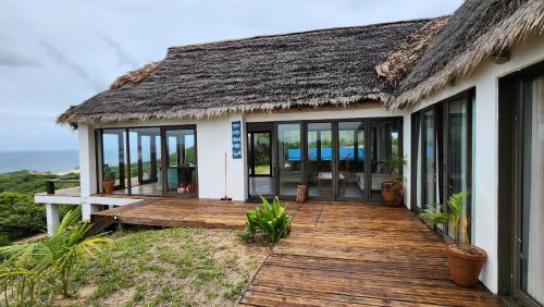 a house with a wooden deck with a view of the ocean at Luxury Beach Villa - Mozambique in Inhambane