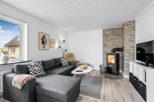 a living room with a couch and a fireplace at Nyd den skønne natur ved hav og fjord in Thyborøn