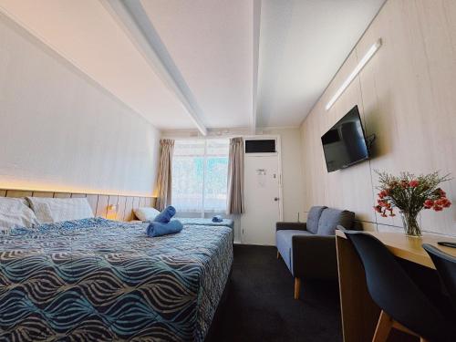 a bedroom with a blue teddy bear sitting on a bed at Seymour Motel in Seymour