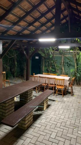 a patio with a table and chairs under a pavilion at Hotel Natur Campeche in Florianópolis