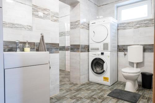 a laundry room with a washer and dryer in it at InSpiral Peaceful Retreats in Kismaros