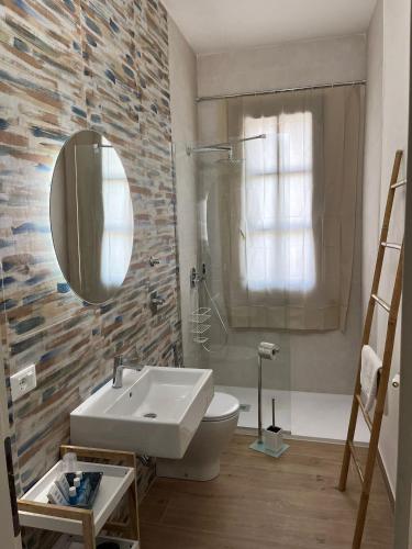 a bathroom with a sink and a toilet and a mirror at Il Glicine in Marsala