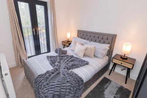 a bedroom with a large bed with a large window at The Broad Oaks in Olton