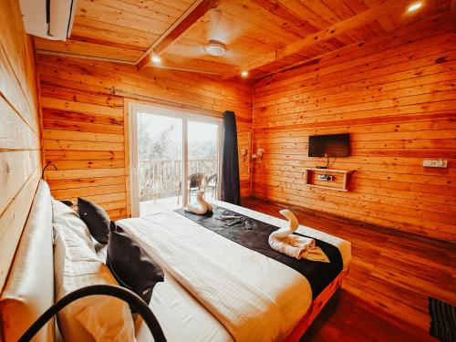 dos patos sentados en una cama en una habitación con paredes de madera en The Lazy Cabanas, en Candolim