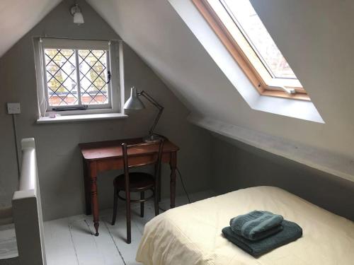 a bedroom with a desk and a bed and a window at Hastings Old Town. Cottage - by the sea in Hastings