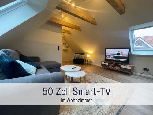 a living room with a couch and a tv at moderne-Kate-Kiel Apartment Jouri in Kiel