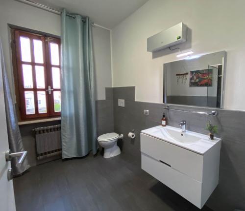 y baño con lavabo blanco y aseo. en Villa Magellano, en Castelnuovo del Garda