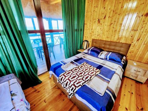 - une chambre avec un lit et une grande fenêtre dans l'établissement GUEST HOUSE NONA, à Chakvi