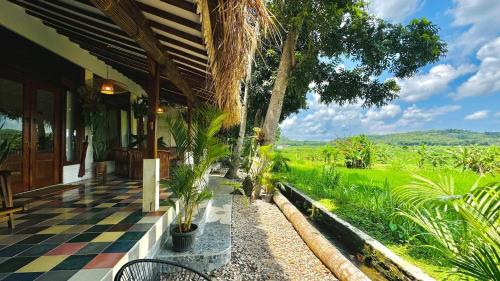 a porch of a house with a checkered floor at Villa Sare - House with panorama rice field view in Yogyakarta