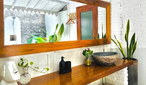 a bathroom counter with a sink and a mirror at Villa Sare - House with panorama rice field view in Yogyakarta