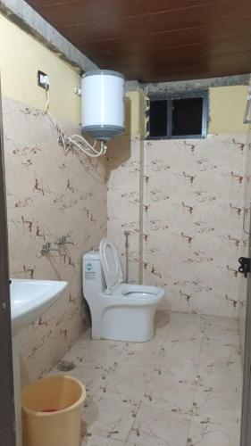 een badkamer met een toilet, een wastafel en een emmer bij Sitapur Dharmasala by prithvi yatra hotels in Gaurikund