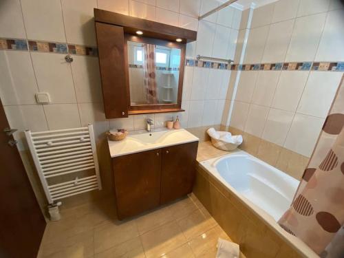 a bathroom with a sink and a bath tub at Spacious & Modern New Apartment in Heraklio Town