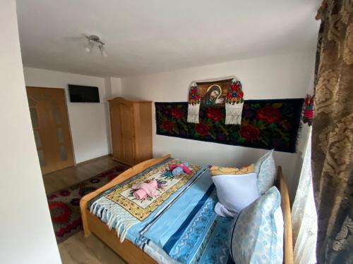 a small bedroom with a bed and flowers on the wall at Pensiunea Casa Andrei in Bîrsana