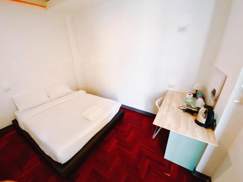 GO INN Silom - BTS Surasak station في Yan Nawa: غرفة صغيرة بها سرير وطاولة
