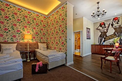 a room with two beds and a wall covered in flowers at Stare Kino Cinema Residence in Łódź