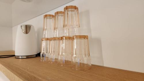 a group of glass vases sitting on a wooden shelf at צ'יל ורוגע עם ג'קוזי וגינה פרטית in Bayit Wegan