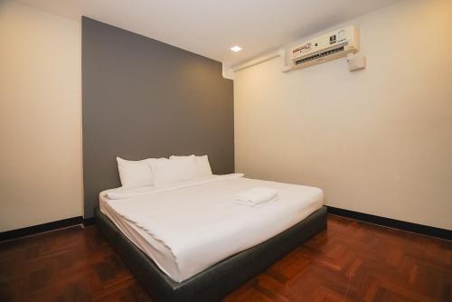 GO INN Silom - BTS Surasak station في Yan Nawa: غرفة نوم بسرير ذو شراشف بيضاء
